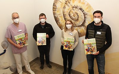 Dankbar nahmen die Mitarbeitenden der KJF Klinik Sankt Elisabeth, Dr. Florian Wild (links), Dr. Andrea Tropschuh und Dr. Nikolaus Halwas (rechts), die Lernbücher von Michael Muhr (2. v.l.), 3. Vorsitzender des Vereins „Landwirtschaft verbindet Bayern e. V.“, in Empfang. Foto: KJF Augsburg / Thomas Bauch 