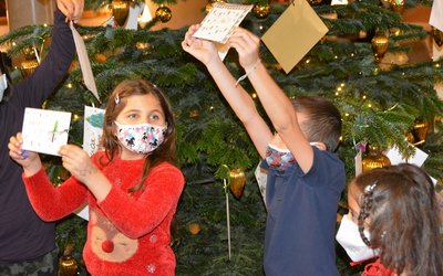 Die Kinder des Frère-Roger-Kinderzentrums freuen sich jedes Jahr, ihre selbstgestalteten Briefumschläge an den Wunschbaum im Hotel Maximilian‘s zu hängen. Foto: KJF Augsburg/Jasmin Mächtlinger